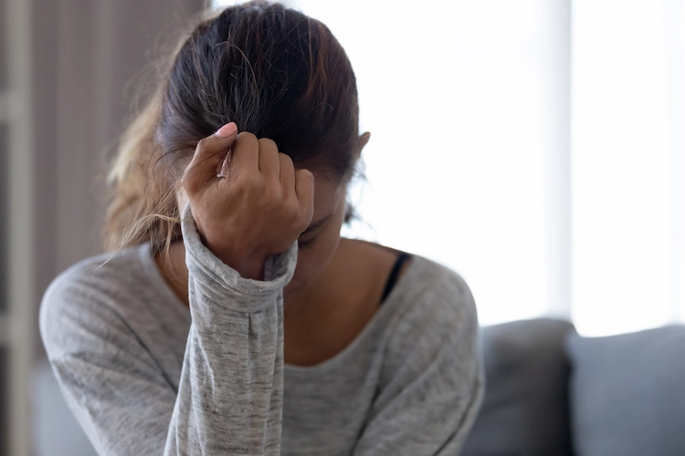 a lady with her head in her hands worrying about drug addiction treatment